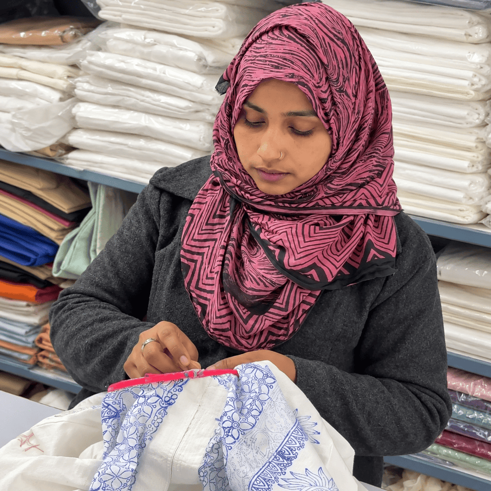 Portrait of a real hand embroidery artisan, with a garment they worked on.