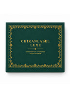 Overhead view of premium green gift box showcasing ornamental gold floral border and luxury branding