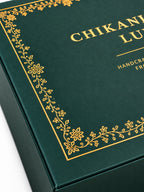 Close-up of elegant gold floral detailing and textured green surface on CHIKANLABEL LUXE premium gift box