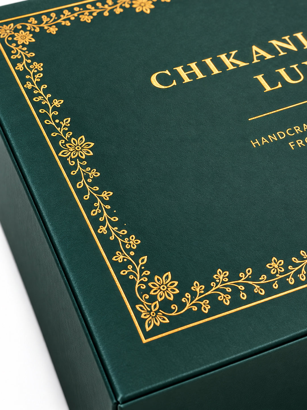 Close-up of elegant gold floral detailing and textured green surface on CHIKANLABEL LUXE premium gift box